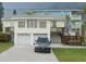Two-story home featuring a two car garage, wood stairs, and a well-manicured lawn at 300 N 22Nd St, Bradenton Beach, FL 34217