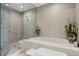 Luxurious bathroom with a soaking tub, walk-in shower, and elegant tile work at 301 Quay Commons # 1709, Sarasota, FL 34236