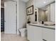 Bright bathroom with a sleek white vanity, modern fixtures, and an open door to a walk-in closet at 301 Quay Commons # 1709, Sarasota, FL 34236
