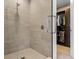Contemporary bathroom with a glass-enclosed shower and open doorway to a custom walk-in closet at 301 Quay Commons # 1709, Sarasota, FL 34236
