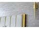 Close up on textured wallpaper detail, padded headboard with gold trim, and gold sconce at 301 Quay Commons # 1709, Sarasota, FL 34236