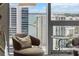 Sitting area in bedroom features chairs with city and ocean views from large windows at 301 Quay Commons # 1709, Sarasota, FL 34236