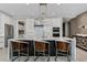 Modern kitchen features white cabinets, stainless steel appliances, and a large island with seating at 301 Quay Commons # 1709, Sarasota, FL 34236