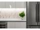 Modern kitchen featuring white cabinets, stainless steel refrigerator, and a unique backsplash at 301 Quay Commons # 1709, Sarasota, FL 34236