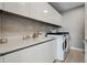 Modern laundry room with white cabinetry, countertop, sink, and washer/dryer at 301 Quay Commons # 1709, Sarasota, FL 34236
