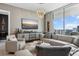 Bright living room features modern decor, including a stylish chandelier and large windows with a view at 301 Quay Commons # 1709, Sarasota, FL 34236