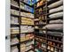 Organized walk-in pantry with dark wood shelving, stocked with towels, shoes, and other household items at 301 Quay Commons # 1709, Sarasota, FL 34236
