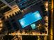 Aerial view of a stunning pool area at night, complete with palm trees at 301 Quay Commons # 1709, Sarasota, FL 34236