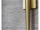 Contemporary wall sconce detail with gold accents against a textured wall covering at 301 Quay Commons # 1709, Sarasota, FL 34236