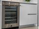 Kitchen has a modern wine fridge with glass door and sleek cabinetry at 301 Quay Commons # 1709, Sarasota, FL 34236