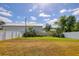 Expansive backyard enclosed by a white fence with lush green grass at 309 Blue Point Dr, Ruskin, FL 33570