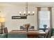 Dining area with rustic wood table, modern chandelier, and large window for ample light at 309 Blue Point Dr, Ruskin, FL 33570