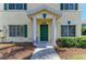 Inviting townhouse front door with decorative wreath, green trim, and well-maintained landscaping at 311 Cape Harbour Loop # 108, Bradenton, FL 34212