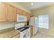 Clean kitchen featuring light wood cabinetry, granite countertops, and modern appliances at 311 Cape Harbour Loop # 108, Bradenton, FL 34212