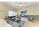 Cozy living room with large windows, plush seating, ceiling fan, and stylish decorative elements at 311 Cape Harbour Loop # 108, Bradenton, FL 34212