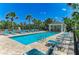 Bright community pool with lounge chairs, blue skies, and palm trees in a tropical resort-like setting at 311 Cape Harbour Loop # 108, Bradenton, FL 34212