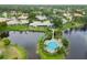 Aerial view of a home and its lakefront community pool with surrounding tropical landscaping at 3130 Ringwood Mdw # 44, Sarasota, FL 34235