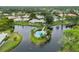 Aerial view of community pool on an island with a lake and surrounding homes at 3130 Ringwood Mdw # 44, Sarasota, FL 34235