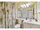 Bright bathroom featuring a shower, vanity, and tropical-themed shower curtain at 3130 Ringwood Mdw # 44, Sarasota, FL 34235