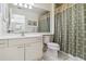 Bathroom featuring tile flooring, white cabinets, a toilet, sink and a shower behind a patterned curtain at 3130 Ringwood Mdw # 44, Sarasota, FL 34235