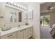 Bathroom featuring carpet, white cabinets, a sink and an oversized mirror with vanity lights at 3130 Ringwood Mdw # 44, Sarasota, FL 34235