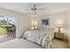 Primary bedroom features a queen bed, ceiling fan, ensuite access and sliding glass doors to a patio at 3130 Ringwood Mdw # 44, Sarasota, FL 34235