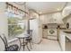 Bright kitchen featuring white appliances, cabinets, granite counters and a breakfast table by a sunny window at 3130 Ringwood Mdw # 44, Sarasota, FL 34235