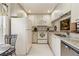 Bright white kitchen featuring white appliances, cabinets, granite counters and a stainless steel dishwasher at 3130 Ringwood Mdw # 44, Sarasota, FL 34235