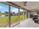 Enclosed lanai with tile floor, ceiling fan and sliding doors with a view of the backyard and pond at 3130 Ringwood Mdw # 44, Sarasota, FL 34235