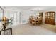 Open-concept living and dining area with neutral carpet, natural light, and a view of the front entrance at 3130 Ringwood Mdw # 44, Sarasota, FL 34235