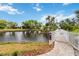 Papillon community pool access over a picturesque bridge surrounded by lush greenery and waterfront views at 3130 Ringwood Mdw # 44, Sarasota, FL 34235