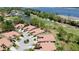 Aerial view showcasing a coordinated community bordering a pond, golf course, and the bay at 3412 E Chelmsford Ct # 42, Sarasota, FL 34235
