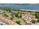An aerial view of coordinated homes near a golf course and pond with a backdrop of the bay at 3412 E Chelmsford Ct # 42, Sarasota, FL 34235
