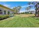 Manicured backyard overlooking the golf course featuring a well-maintained lawn and mature trees at 3412 E Chelmsford Ct # 42, Sarasota, FL 34235