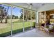 Sunroom featuring tiled floors, ceiling fan, and stunning views of the golf course and manicured lawn at 3412 E Chelmsford Ct # 42, Sarasota, FL 34235