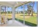 Bright Florida room with sliding glass doors showcasing a picturesque view of the golf course and lush landscaping at 3412 E Chelmsford Ct # 42, Sarasota, FL 34235
