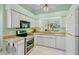 Bright kitchen features modern appliances, tile floors, and ample counter space for cooking prep at 3412 E Chelmsford Ct # 42, Sarasota, FL 34235