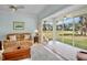 Bright living room featuring a comfortable leather sofa, large windows, and stunning golf course views at 3412 E Chelmsford Ct # 42, Sarasota, FL 34235