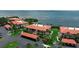Scenic aerial view of waterfront condo community featuring lush landscaping, red tile roofs, and ample parking at 3420 Wild Oak Bay Blvd # 120, Bradenton, FL 34210