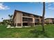 Rear view of condominium complex with lush lawn and access stairs to the upper floors at 3420 Wild Oak Bay Blvd # 120, Bradenton, FL 34210