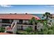 Exterior view of condo building with balconies, red tile roof, and tropical landscaping, showcasing waterfront living at 3420 Wild Oak Bay Blvd # 120, Bradenton, FL 34210