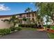 Exterior of a condo building with balconies, red mulch landscape, and tropical foliage by the water at 3420 Wild Oak Bay Blvd # 120, Bradenton, FL 34210