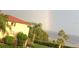 Attractive condo building with a red tile roof next to lush landscaping, with the ocean and a rainbow in the distance at 3420 Wild Oak Bay Blvd # 120, Bradenton, FL 34210
