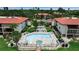 Community pool and hot tub area with lounge chairs surrounded by condos and tropical landscaping at 3420 Wild Oak Bay Blvd # 120, Bradenton, FL 34210