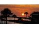 Beautiful waterfront view featuring palm trees silhouetted against a vibrant sunset at 3420 Wild Oak Bay Blvd # 120, Bradenton, FL 34210
