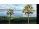 Picturesque waterfront view featuring palm trees and reflective water under a partly cloudy sky at 3420 Wild Oak Bay Blvd # 120, Bradenton, FL 34210
