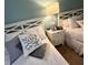 Cozy bedroom featuring two twin beds with stylish pillows and a white nightstand at 3506 54Th W Dr # 103, Bradenton, FL 34210
