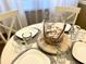 Set dining table with nautical themed tablescape and white chargers at 3506 54Th W Dr # 103, Bradenton, FL 34210