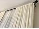 Window with white floor-to-ceiling curtains on a black curtain rod at 3506 54Th W Dr # 103, Bradenton, FL 34210