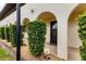 Arched entryway leads to the front door, lined with trimmed bushes and decorative rocks at 3690 Pinecrest St # 114, Sarasota, FL 34232